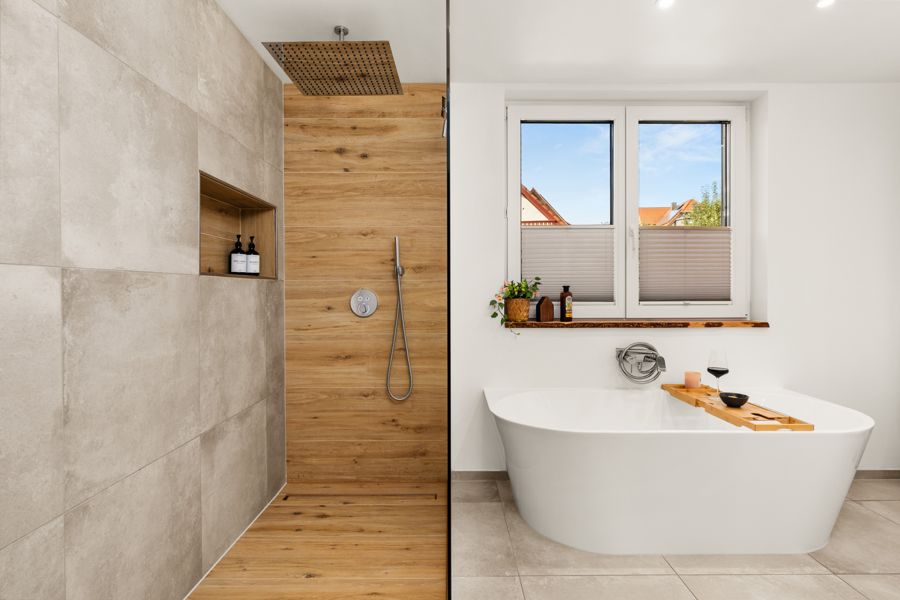 Badezimmer mit Regendusche und freistehender Badewanne im Premium Ferienhaus Schauenburg